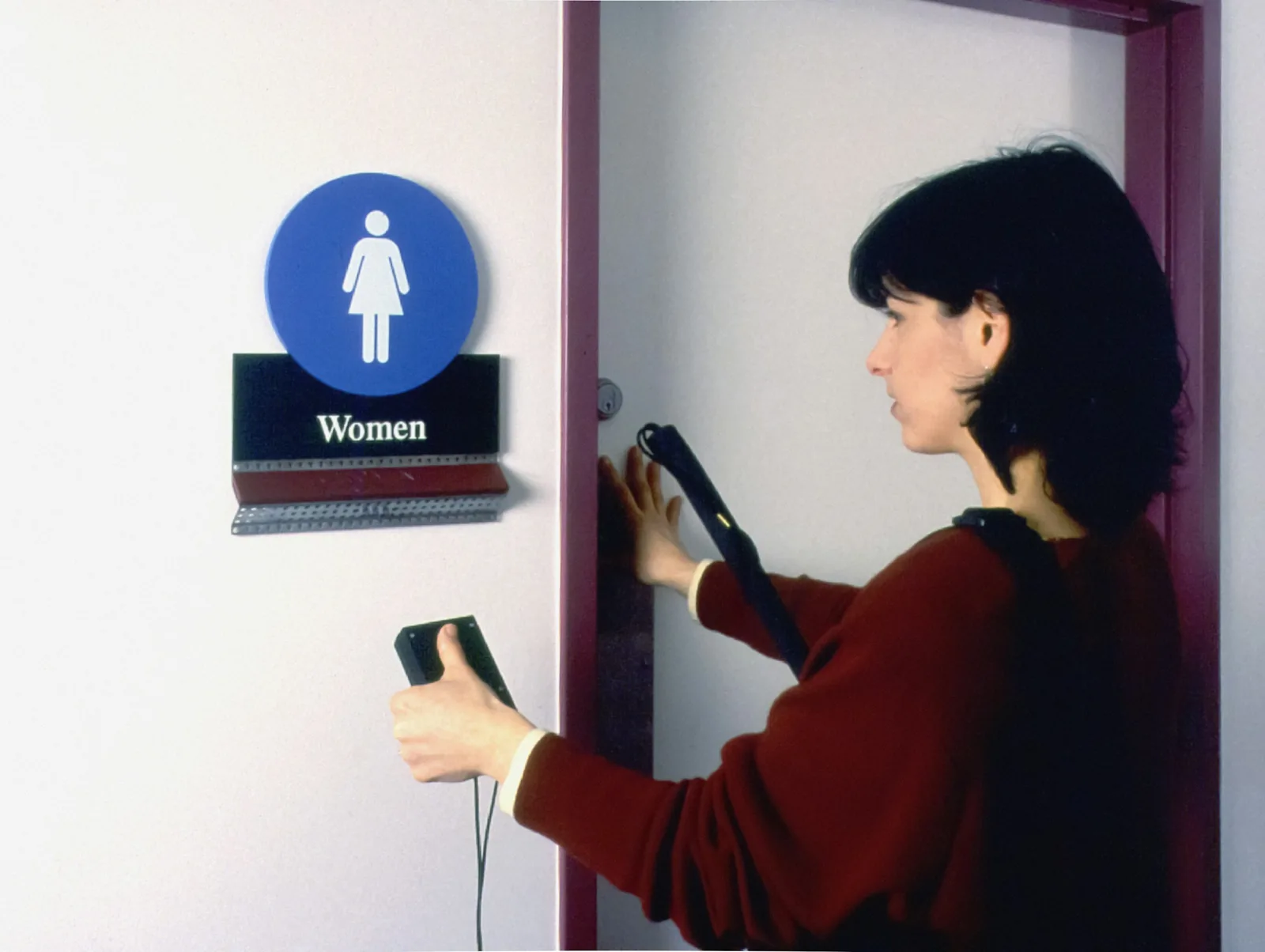 Woman drying her hair with a handheld hair dryer, illustrating compact travel hair dryers