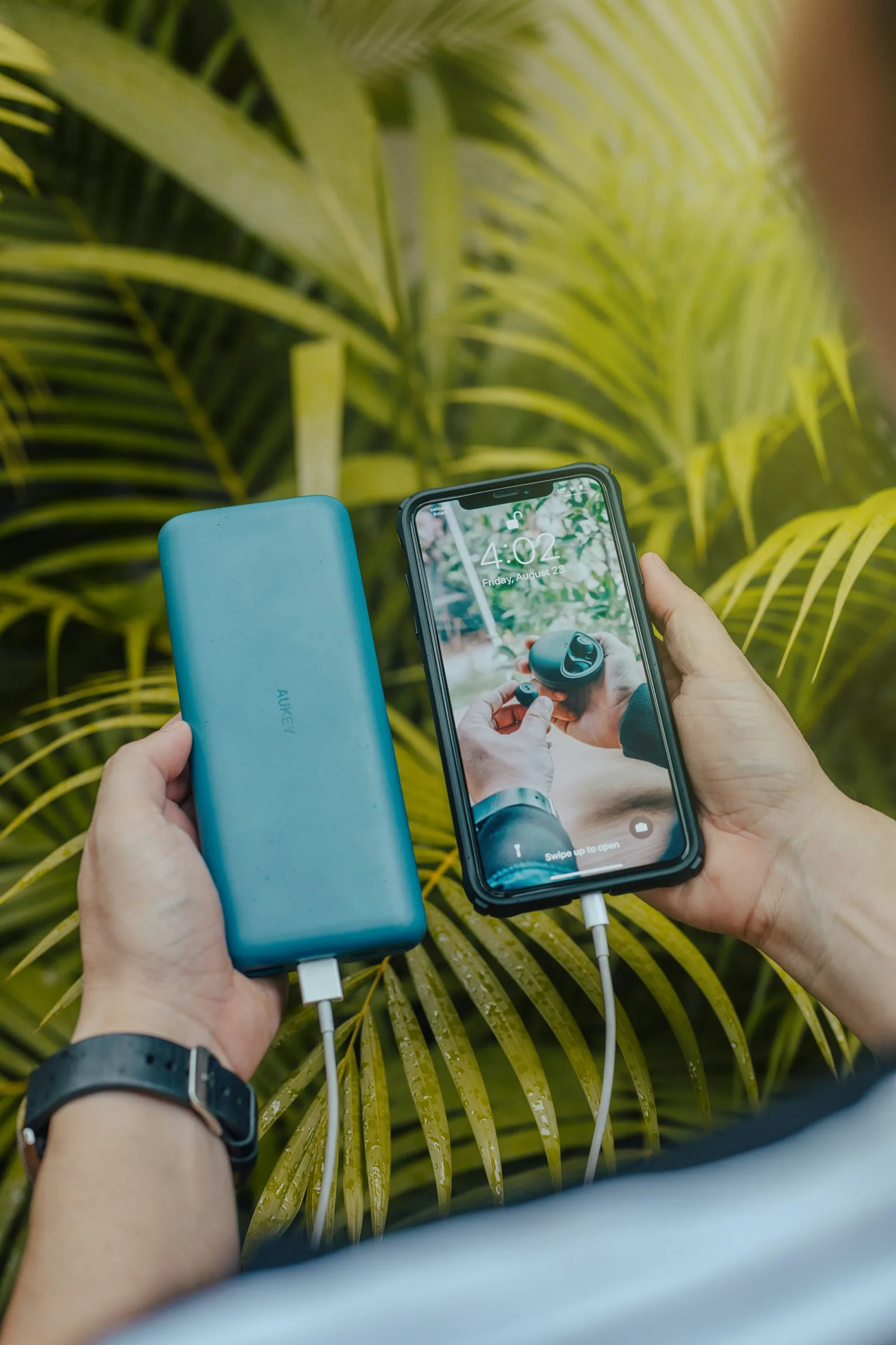 Smartphone connected to a green power bank, a typical travel charging setup